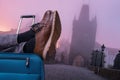 Tourist is relaxing at Charles Bridge in Prague with legs on his luggage. Travel concept.