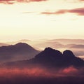 Tourist resort in Saxony. Fantastic dreamy sunrise on the top of the rocky mountain with the view into misty valley Royalty Free Stock Photo