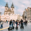 Tourist rides a electric scooter Segway on old square on background of the Church Of Our Lady Before Tyn In Old Town Royalty Free Stock Photo