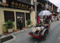 Tourist riding old vintage trishaw or beca around Georgetown