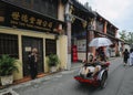 Tourist riding old vintage trishaw or beca around Georgetown