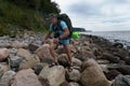 A tourist on a rocky beach, Baltic sea, a man with a backpack walks over rocks Royalty Free Stock Photo