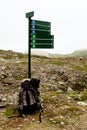 Tourist route pointer in the mountains and backpack