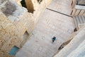 A tourist with a rucksack walks through the narrow, cobbled streets of the citadel in Victoria, Gozo. The walls of the houses are