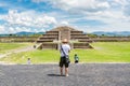 Tourist in the ruins of the architecturally significant Mesoamerican pyramids and green grassland located at at Teotihuacan, an