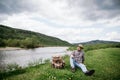 The tourist sat down to rest on the banks of a mountain river after a difficult and long hiking route in the mountains