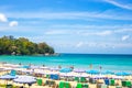 Tourist seaside resort in Asia. Vacationers tourists, rows of sun loungers and umbrellas on the sea beach. Rest and