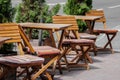 A row of empty wooden tables and chairs in a street cafe Royalty Free Stock Photo