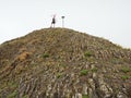 Tourist on sharp basalt peak of volcano formation Royalty Free Stock Photo