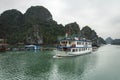 Tourist ship sailing among floating fisherman village in ha long bay, northern vietnam