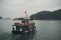 Tourist ship sailing among floating fisherman village in ha long bay,