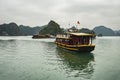 Tourist ship sailing among floating fisherman`s village in ha long bay, northern vietnam