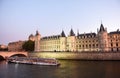 Tourist ship on the Seine river and Conciergerie building at the background in Paris, France