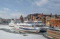 Tourist ships mooring in ice during winter in Old Town of Gdansk Poland. Old town in the background. Royalty Free Stock Photo