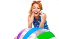 Tourist in shorts and a t-shirt cute talking on the phone and leans on an inflatable ball on a white background