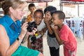 A tourist shows young Burmese children their photo