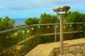 A tourist sight-seeing binocular telescope overlooks the ocean under a blue cloudy sky Royalty Free Stock Photo