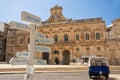 Tourist signpost with distances and in the background the Municipality of Ostuni Italy Royalty Free Stock Photo