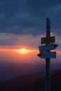 Tourist signpost on a mountain road at sunset