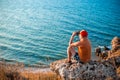 a tourist sits on the top of a mountain and looks through binoculars at the seascape. Travel and tourism Royalty Free Stock Photo