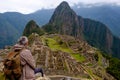 Tourist sitting on his back watching Machu Picchu Lost City of Inca