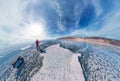 Tourist with sleds walks along the blue ice of Lake Baikal. Wide-angle panorama Royalty Free Stock Photo