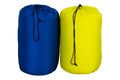 Tourist sleeping bag of yellow and blue color warm for hiking and for a tent, collapsed, isolated on white background.