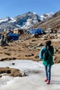 Tourist stand on frozen pond with tourists and market with Yunthang Valley in the background in winter in Zero Point at Lachung. Royalty Free Stock Photo