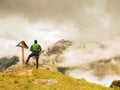 Tourist stand on rocky view point and watching into misty Alpine valley. Royalty Free Stock Photo