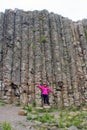 Tourist standing against basalt columns