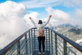 Tourist standing on the observation deck and enjoying of amazing view of mountains peak and clouds Royalty Free Stock Photo