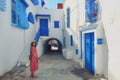 Tourist stands in the courtyard with blue windows and doors with Arabic ornaments. Texture of Islamic symbols in Sidi Bou said, Royalty Free Stock Photo
