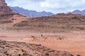 A tourist stands on a hill and takes a Wadi Rum desert photo on his mobile phone near Aqaba city in Jordan Royalty Free Stock Photo
