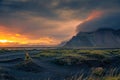 Tourist stands on a sand dune at Vestrahorn mountain in Iceland at sunset Royalty Free Stock Photo