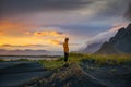 Tourist stands on a sand dune at Vestrahorn mountain in Iceland at sunset Royalty Free Stock Photo