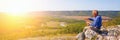 A tourist stands on top of a mountain and admires from above a view of the Ural taiga. Royalty Free Stock Photo