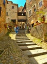 Tourist on the steps in old historic alley in the medieval village of Anghiari near city of Arezzo in Tuscany, Italy Royalty Free Stock Photo