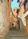 Tourist on the steps in old historic alley in the medieval village of Anghiari near city of Arezzo in Tuscany, Italy Royalty Free Stock Photo