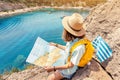 Tourist student with map and greek flag standing on top of the hill at background of the inspirational blue lagoon bay. Solo Royalty Free Stock Photo