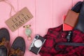 Tourist stuff - bag, passport, camera, compass, shoes, shirt, note pad and blackboard with text Let's travel