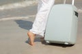 Tourist with suitcase on the beach