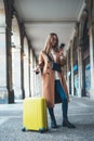 Tourist with suitcase holding smart mobile online phone. Girl travels in Barcelona. Holiday concept in Spain street. Traveler