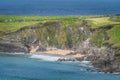 Tourist swimming in the see and relaxing on small hidden Coumeenoole Beach in Dingle