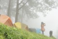 Tourist take photo near tent in mist & fog. camping in forest. p Royalty Free Stock Photo