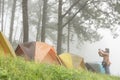 Tourist take photo near tent in mist & fog. camping in forest. p Royalty Free Stock Photo