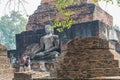 Tourist take photo of old buddha statue in the ancient temple Sukothai Thailand