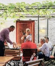 Tourist takes cell phone photo of restaurant server lighting up a flaming cup of Rudesheimer Coffee Royalty Free Stock Photo