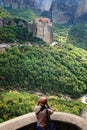 A tourist takes a photo of the amazing panorama of Meteora