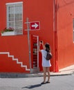 Tourist takes photo of colourful house in the Malay Quarter, Bo Kaap, Cape Town, South Africa. Historical area of painted houses.