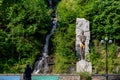 Tourist takes photo of a mountain waterfall Royalty Free Stock Photo